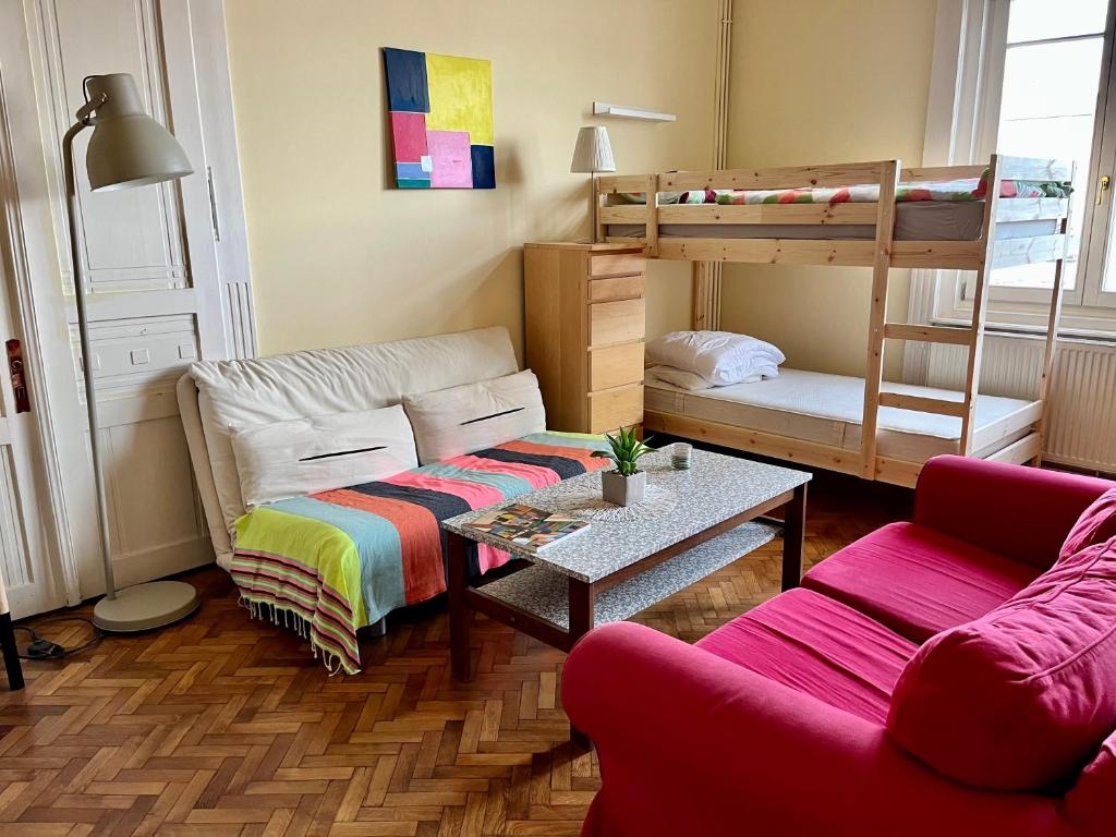 Zen Hostel by Central Market في بودابست: غرفة معيشة مع أريكة وسرير بطابقين