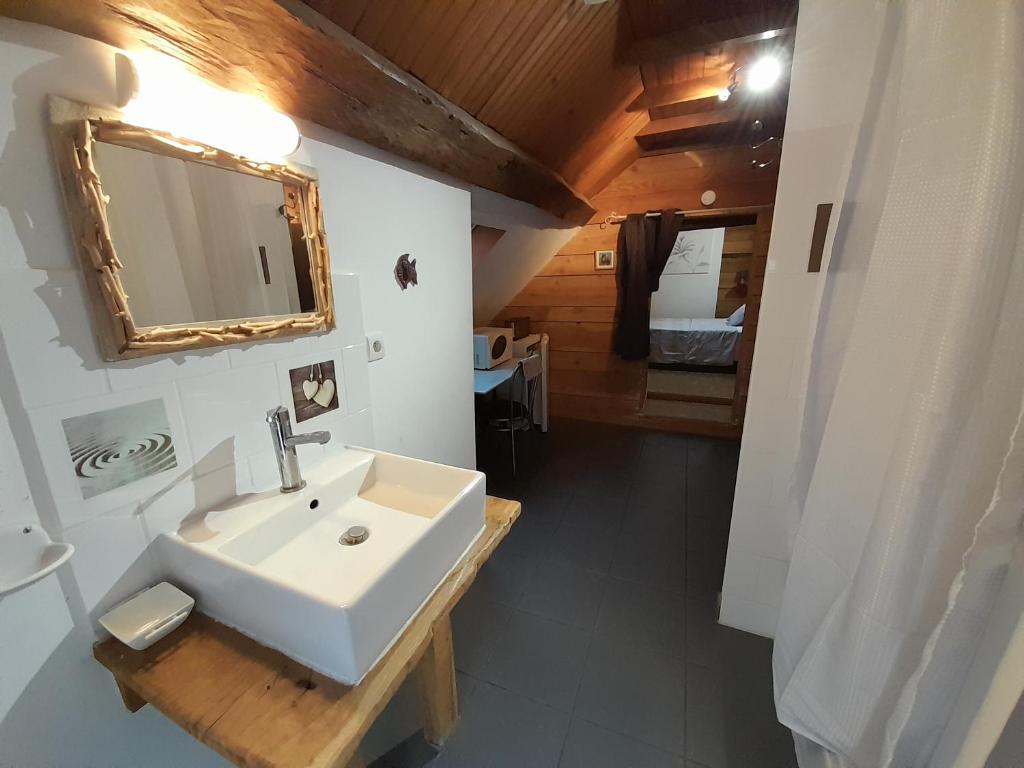 a bathroom with a white sink and a mirror at La cabane: Chambre double, salle de bain privée in Vatan