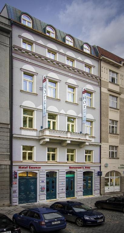 a large white building with cars parked in front of it at Hotel Essence in Prague