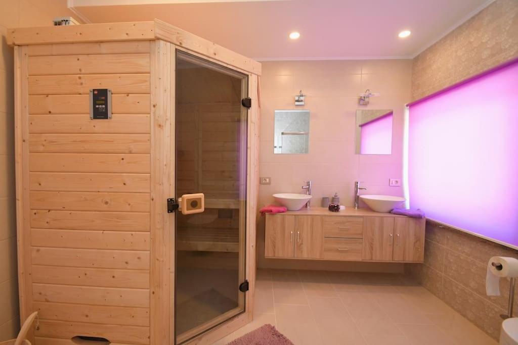 uma casa de banho com 2 lavatórios e uma cabina de duche em vidro. em Relax apartment near Opatija, Sauna, jacuzzi em Marinići