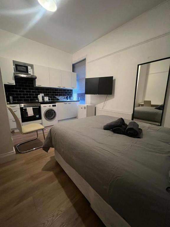 1 dormitorio con 1 cama grande y cocina en Private Self Contained Studio In The Heart Of Golders Green en Londres