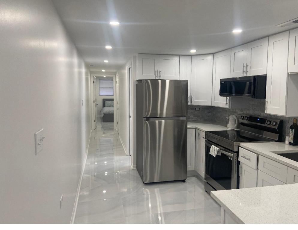 a kitchen with a stainless steel refrigerator and white cabinets at Perfect place to enjoy the city or just relax in Chicago