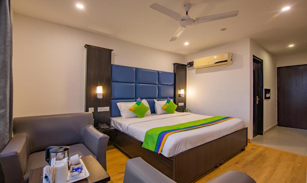 a bedroom with a bed with a couch and a chair at Treebo Trend Chandigarh Grand in Chandīgarh
