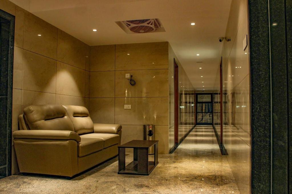 una sala de estar con un sofá y una mesa en RR Mount Elite Suites, en Chennai