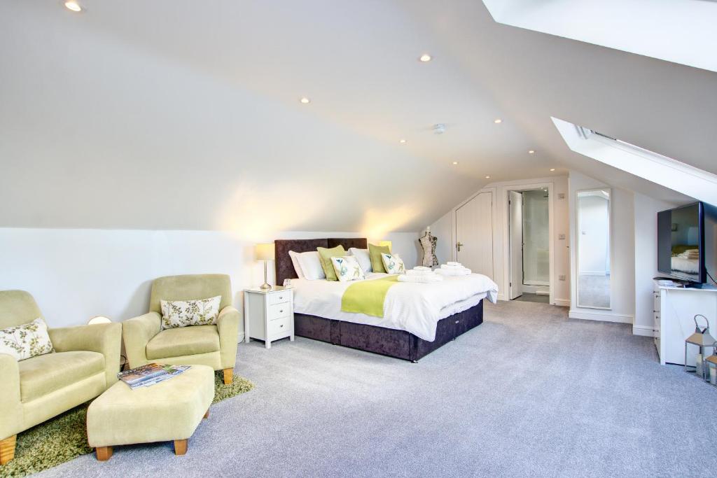 1 dormitorio con 1 cama, 2 sillas y TV en Colman's of Aysgarth Town Ends, en Aysgarth