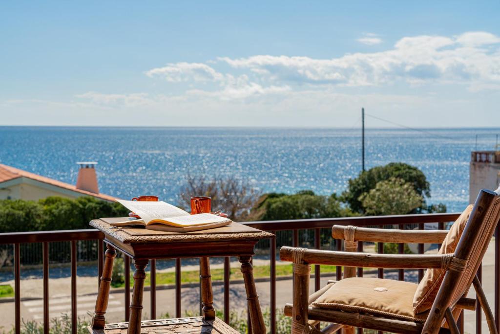 una mesa con un libro y una silla en el balcón en Villa Arrecifes, en Fertilia