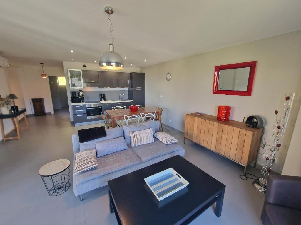 un soggiorno con divano e tavolo di Appartement vue mer Fromontica a Saint-Florent
