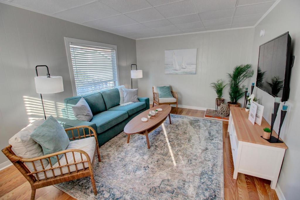 a living room with a blue couch and a table at Adorable 2-bedroom guest house with free parking in Galveston
