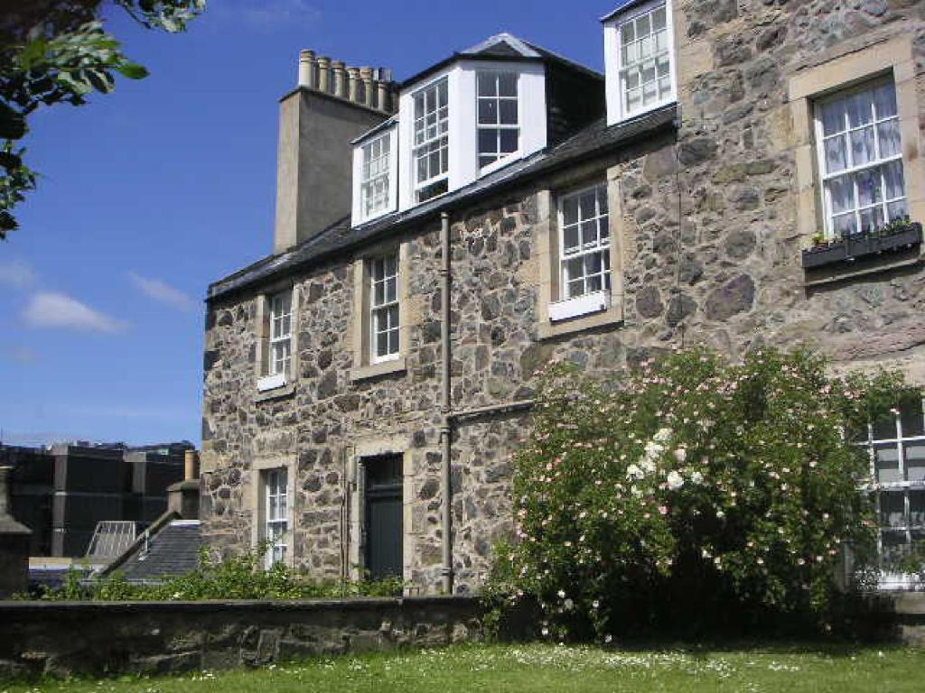 an old stone building with white windows and a bush at CENTRAL Calton Hill What a view in Edinburgh