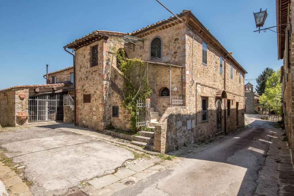 un antiguo edificio de piedra en una calle en Casale Rosennano - Scuderie, en Rosennano