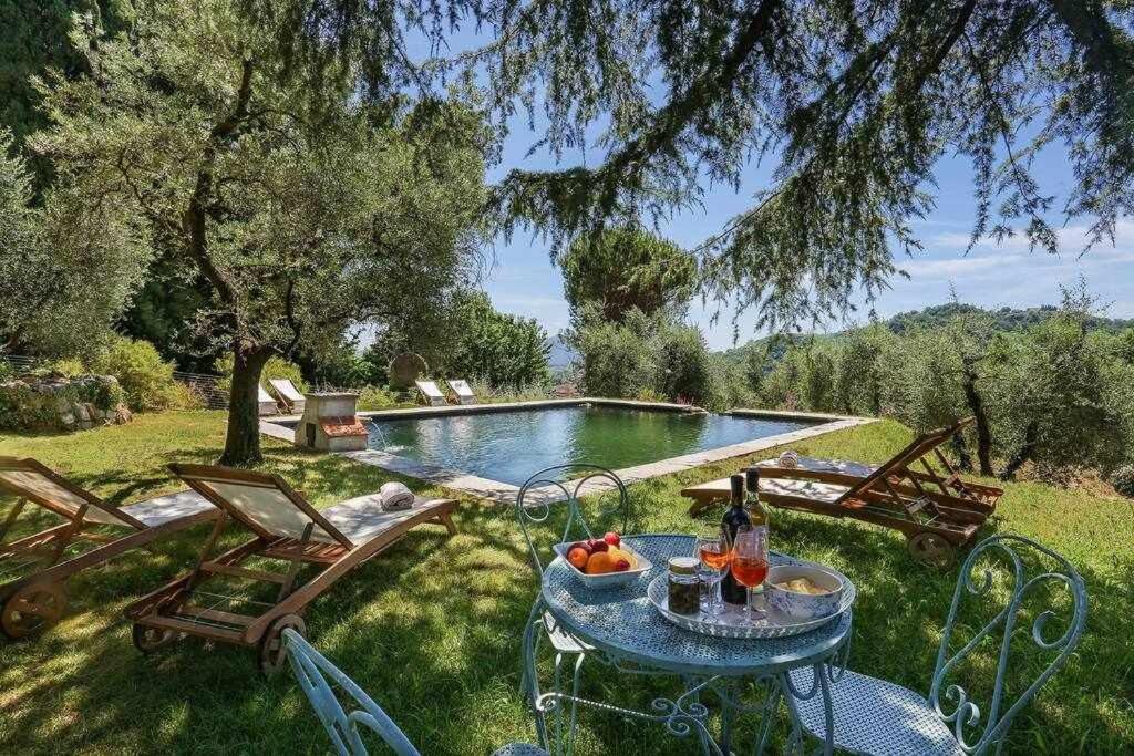 una mesa con fruta junto a una piscina en Tenuta di Tramonte Boutique Hotel en Lucca