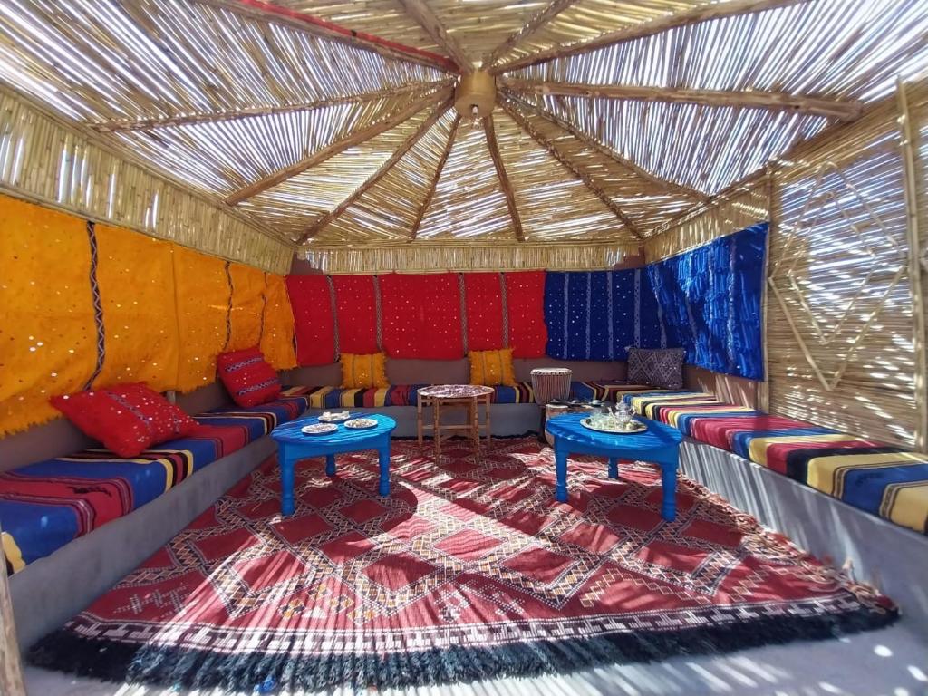 a room with couches and tables in a tent at Riad Hassi Labied Merzouga in Merzouga