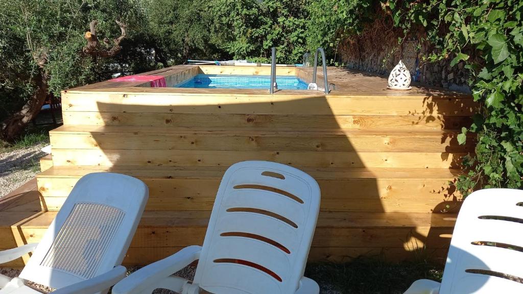 2 sillas y una piscina en el patio trasero en Agriturismo L'Olivara, en Piano di Sorrento