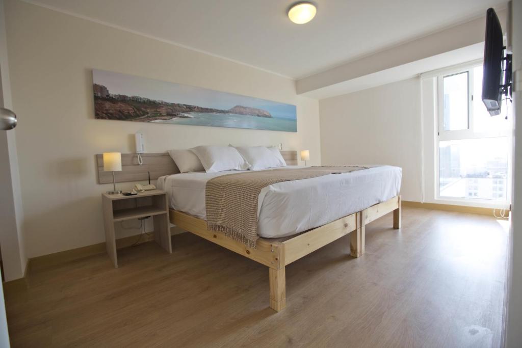 una camera con un grande letto e una finestra di Urbano Apartments Miraflores Pardo a Lima