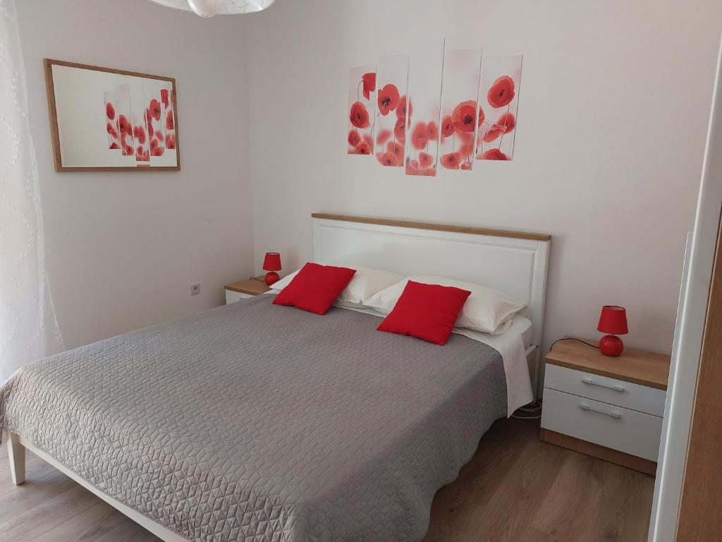 um quarto com uma cama com duas almofadas vermelhas em Soba Ana em Cres