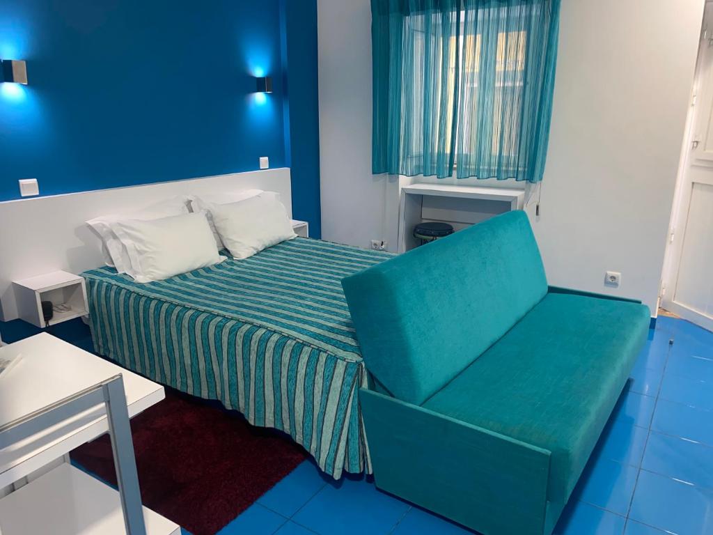 ナザレにあるEstúdio Berlengaのベッドと椅子付きの小さな部屋です。