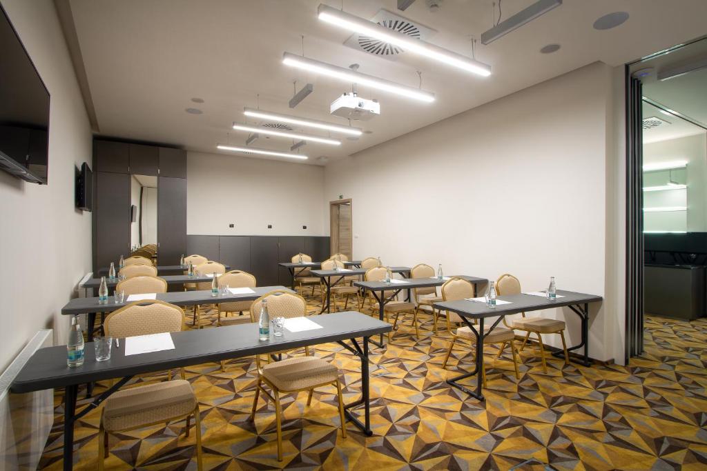 a meeting room with tables and chairs in a room at Hotel Essence in Prague