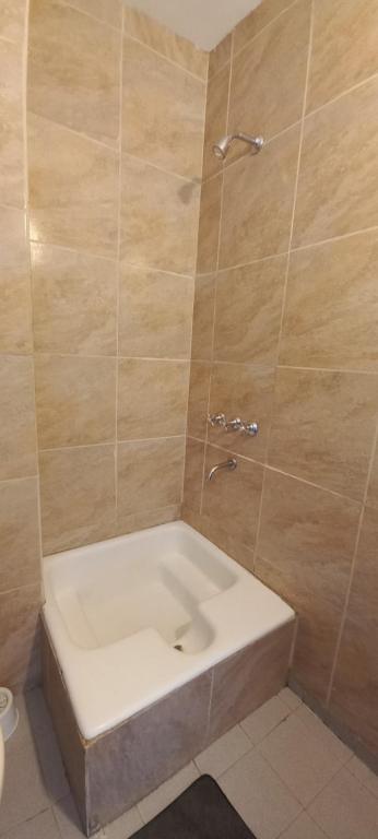 y baño con ducha y bañera blanca. en Departamentos San Martin 2175 en Salta