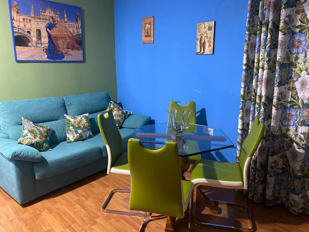 a living room with a blue couch and a glass table at Apartamento Carmona in Carmona