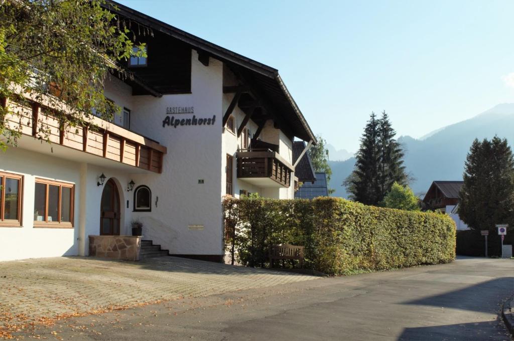 a white building with a hedge in front of it at Gästehaus Alpenhorst in Oberstdorf