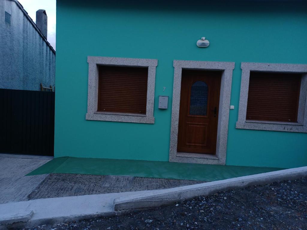 niebieski budynek z drzwiami i dwoma oknami w obiekcie Casa s.pedro visma w mieście A Coruña