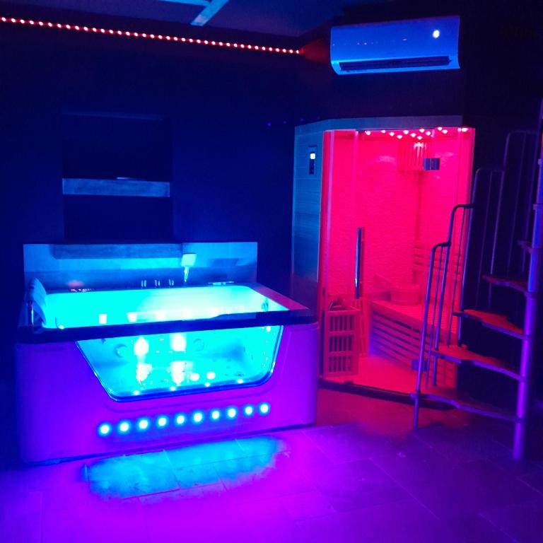 a hot tub in a room with red and blue lights at instant à deux in Précigné