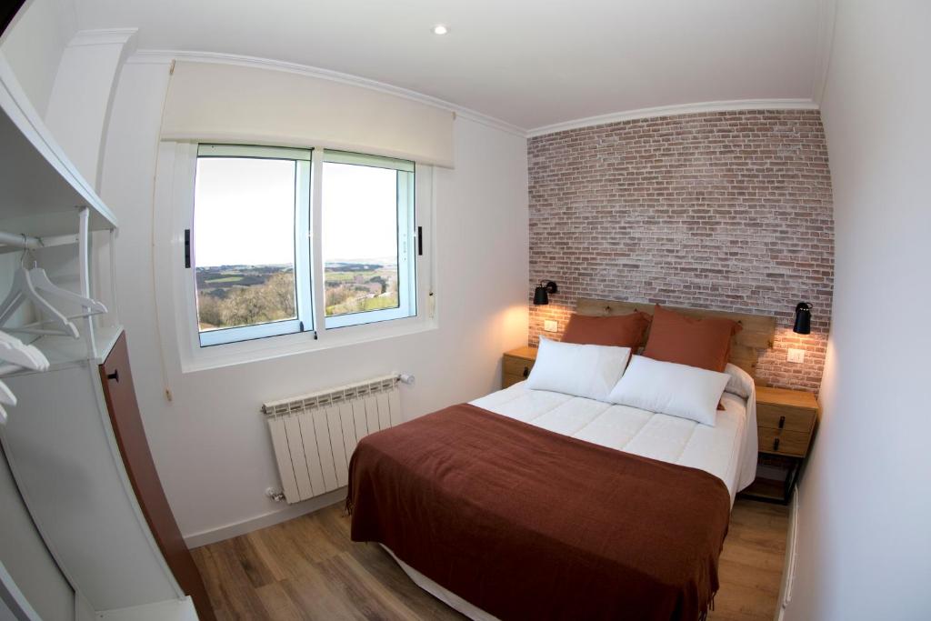a bedroom with a bed and a brick wall at Pension Casa Manolo in Fonsagrada
