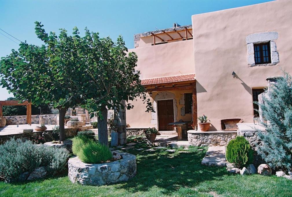 a house with a tree in the yard at Traditional Villa with pool in Sfakia in Ímbros