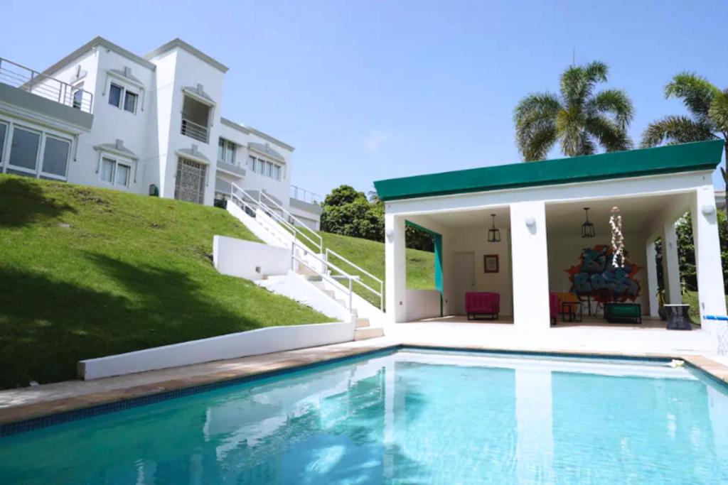 a swimming pool in front of a house at Campestre para familias grupos en Puerto Rico in Luquillo