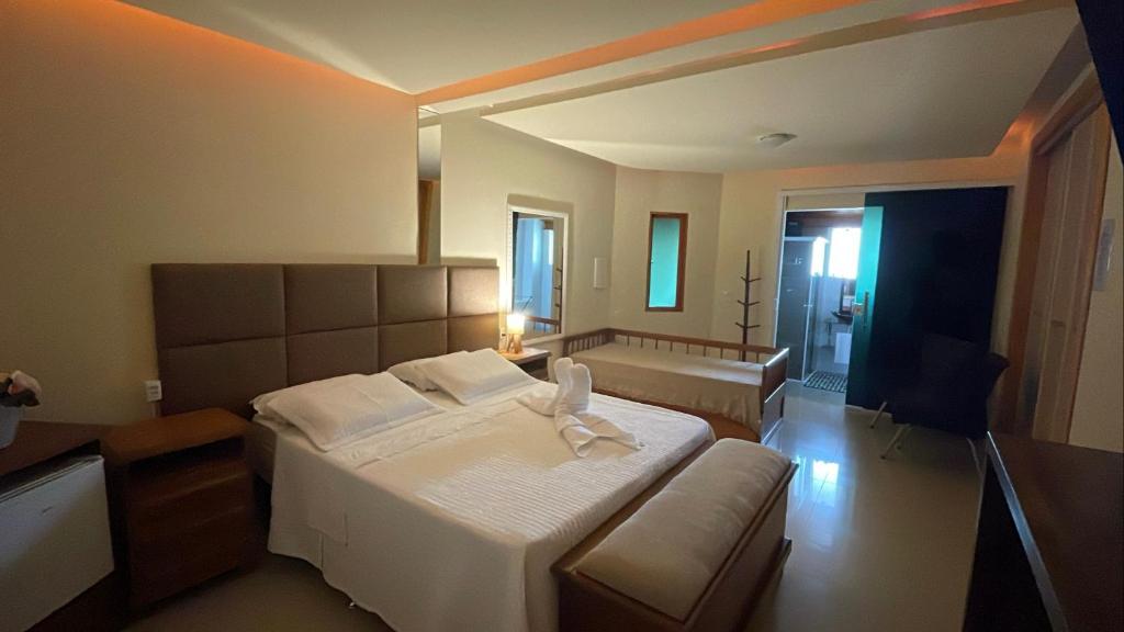 1 dormitorio con 1 cama blanca grande y 1 sofá en Espaço Nobre en Cunha