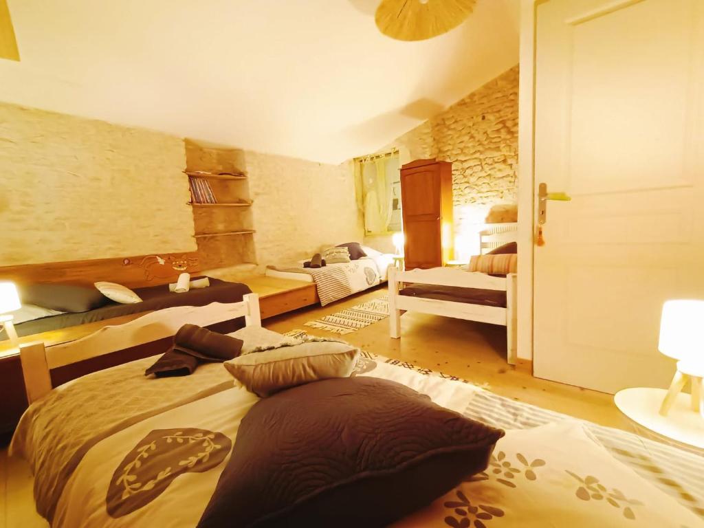 1 dormitorio con 2 camas y almohadas en Gîte 3 étoiles avec SPA, 2 Chambres LE LOGIS DE PEARL, en Salles-sur-Mer