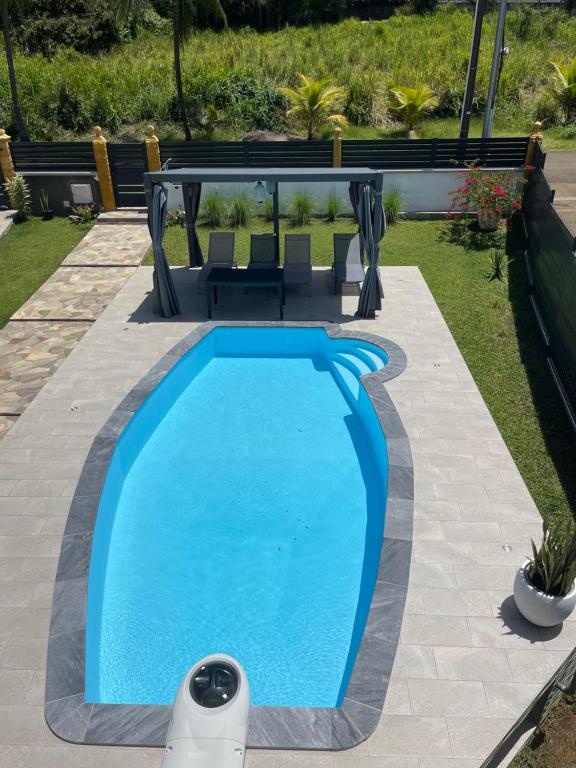 - une piscine dans une cour avec une table et des chaises dans l&#39;établissement Villa corail, à Lamentin