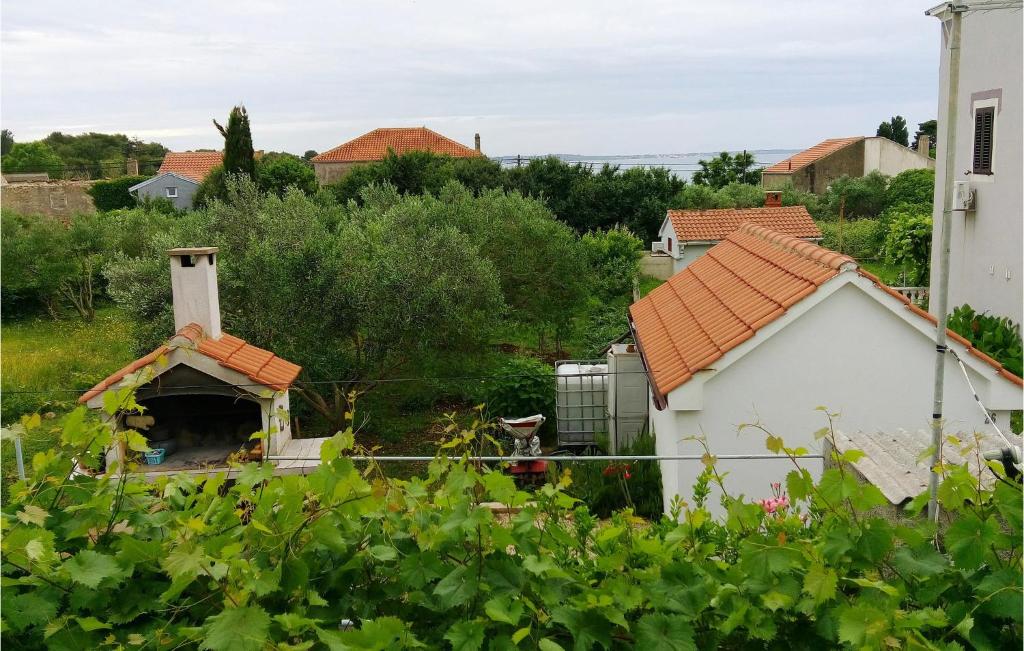 a small white house with a dog in the yard at Cozy Home In Olib With Kitchen in Olib