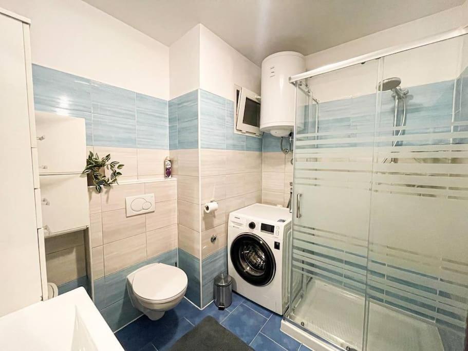 uma casa de banho com um WC e uma máquina de lavar roupa em Apartman Dorja em Fažana