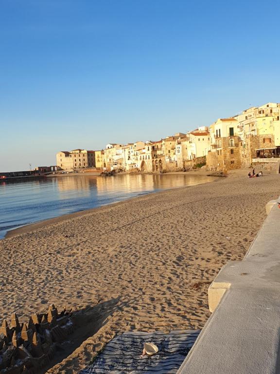 a group of birds standing on a sandy beach at Sunset beach in Cefalù
