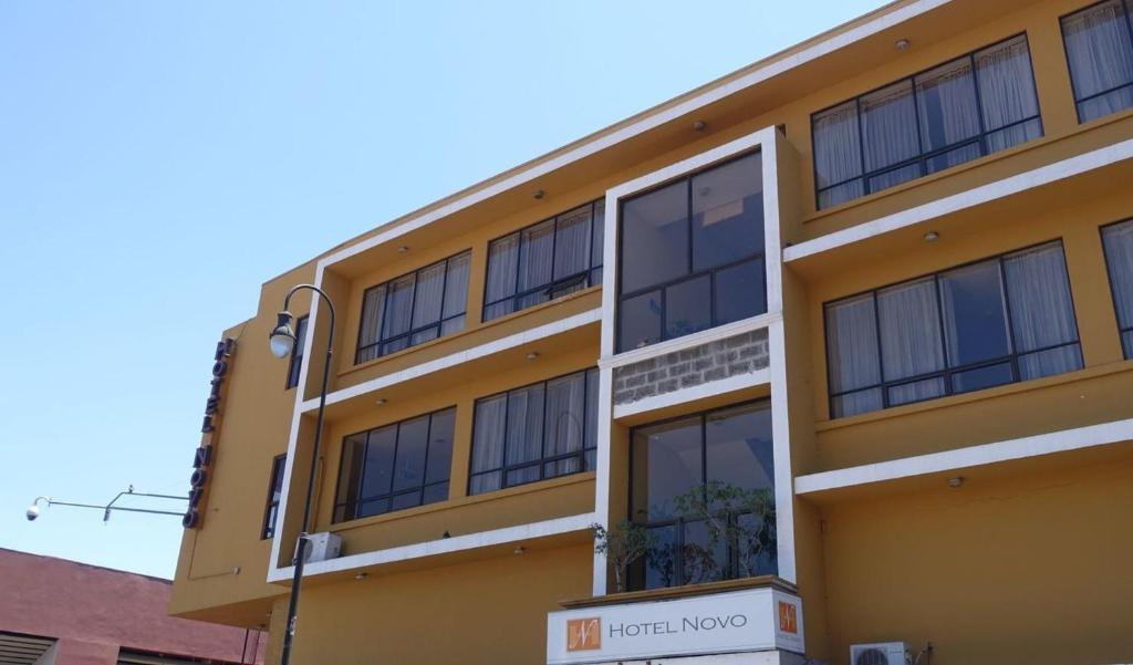 un edificio amarillo con muchas ventanas en Hotel Novo en San José