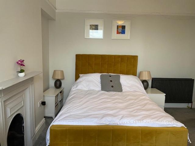 a bedroom with a large bed with a pillow on it at Central en-suite double room in Plymouth