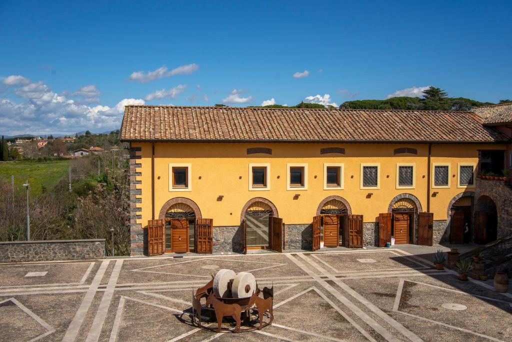 ein gelbes Gebäude mit einer Pferdestatue davor in der Unterkunft Tenuta Borsari in Frascati