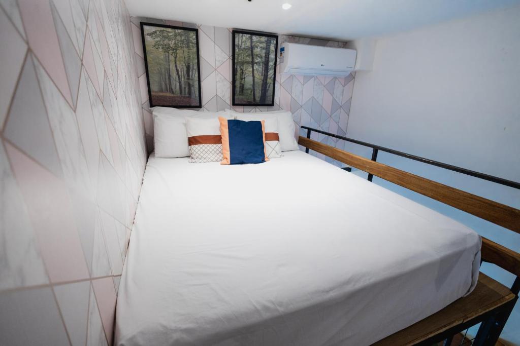 a bed in a small room with two windows at Minicasa Brasileira in Sorocaba