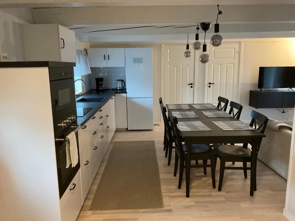 a kitchen and dining room with a table and chairs at Högklint Rövar Liljas Apartment in Visby