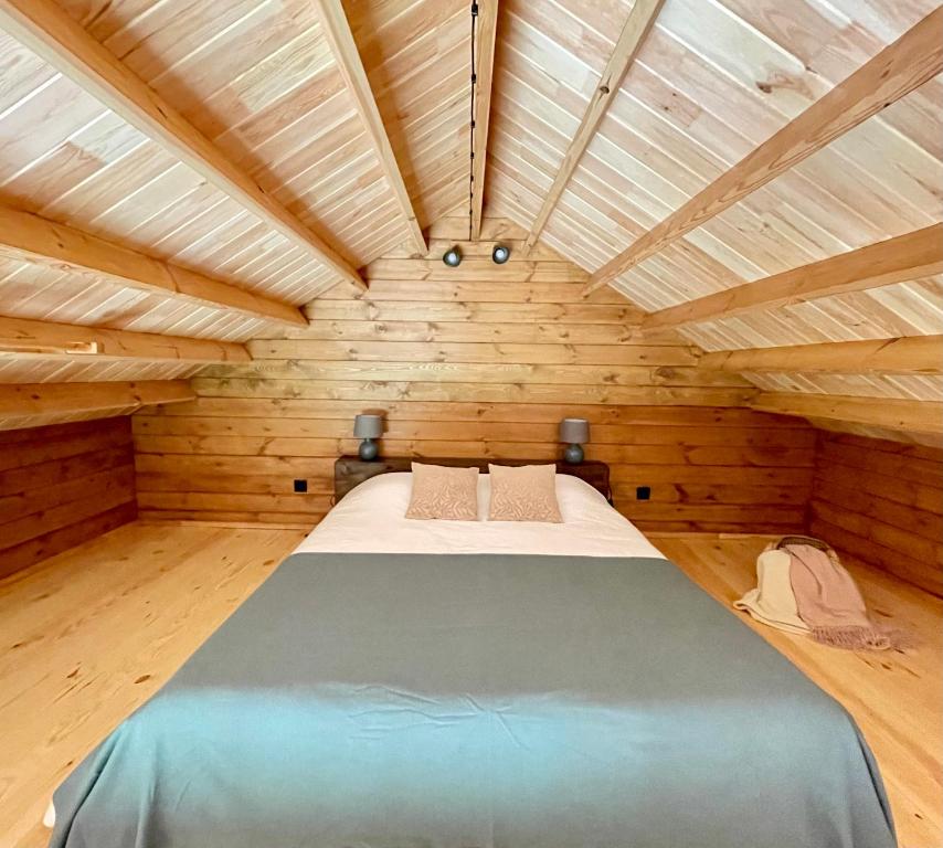 duże łóżko w pokoju z drewnianymi ścianami w obiekcie Mountain Eco Shelter 4 w Funchal