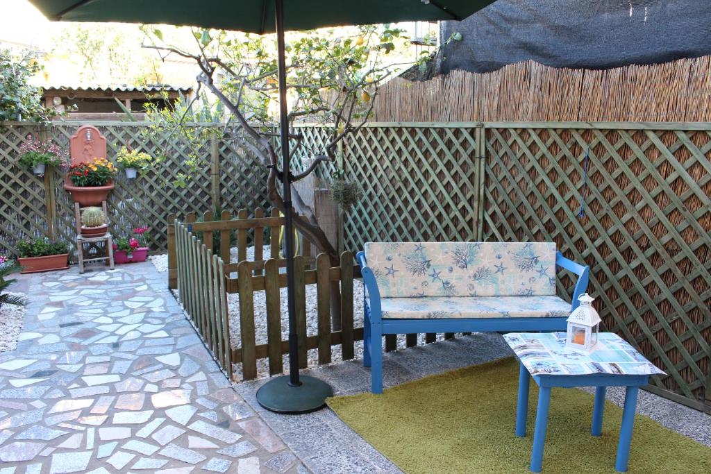 Casa Vacanze Nonna Franca في كابراس: كرسي ازرق وطاولة تحت مظله