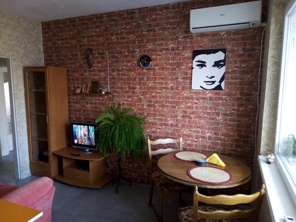 a living room with a table and a brick wall at Victoria's Place in Varna City