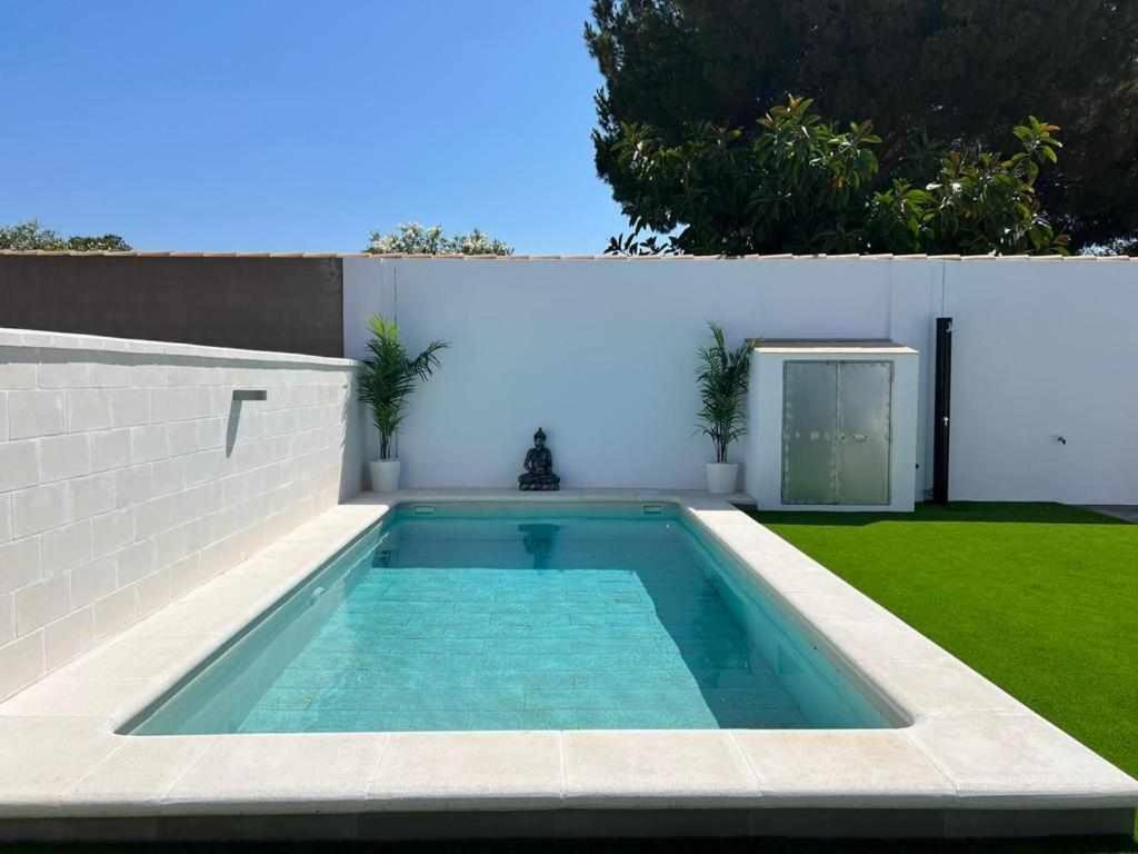 a swimming pool in the backyard of a house at Villa Zen, La Barrosa in Cádiz
