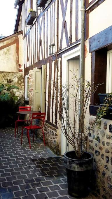 a patio with a table and a bench next to a building at Lovely cottage in Honfleur center in Honfleur