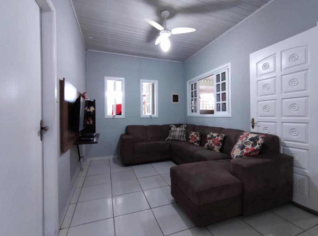 sala de estar con sofá y ventilador de techo en Casa individual aconchegante - Rio da praia - Bertioga, en Bertioga