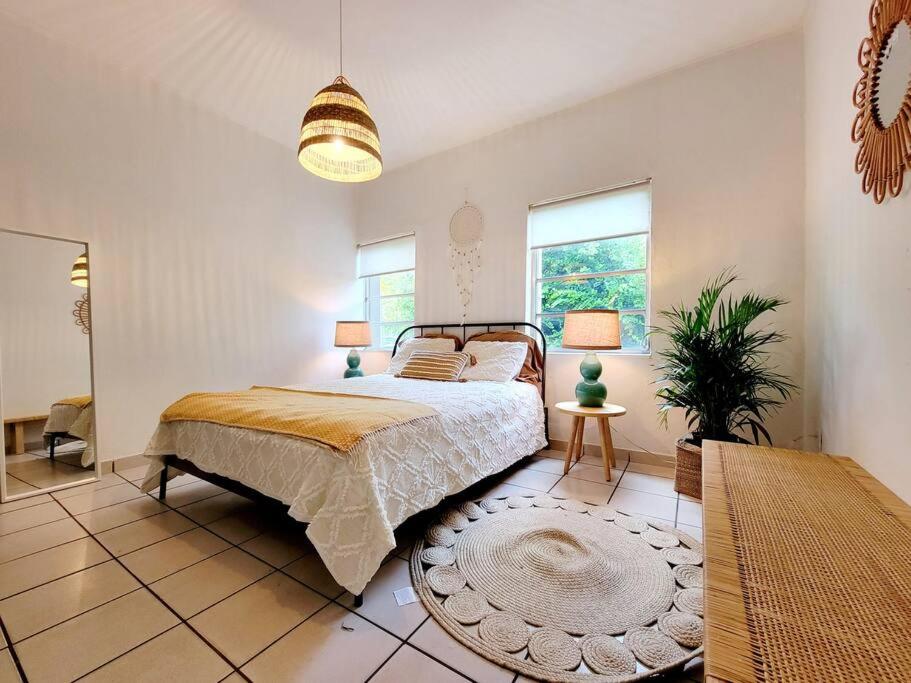 een slaapkamer met een bed en een tafel en ramen bij LITTLE HAVANA/CALLE OCHO 3 - BEST APARTMENT in Miami