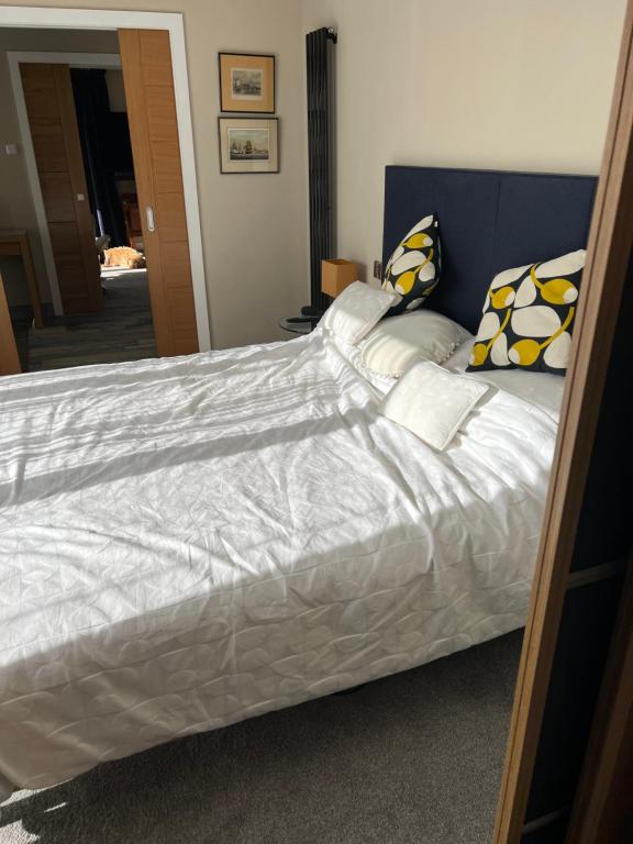a bed with white sheets and pillows on it at Sea breeze Exmouth in Lympstone