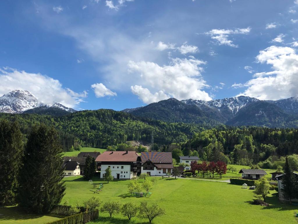 una casa in un campo con montagne sullo sfondo di Agnes Apartman a Latschach