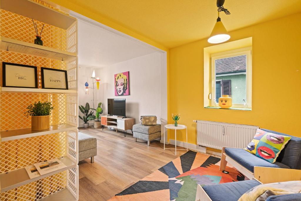 sala de estar con paredes amarillas y sofá en Farbenfrohe Altbauwohnung, TOP Ausstattung (Klima), en Friedrichshafen